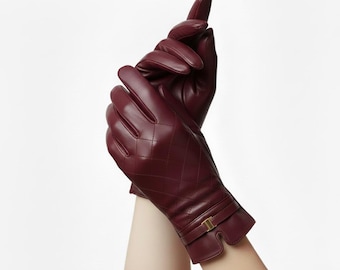 May include: Burgundy leather gloves with a quilted design and a gold buckle detail. The gloves are displayed against a white backdrop. The text "LEATHERMED FORGE" is at the top of the image.