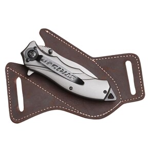 Peut inclure: Un couteau pliant argent&eacute; avec le mot "STRIDER" sur le clip, pos&eacute; dans un &eacute;tui en cuir marron. L'&eacute;tui a des coutures blanches et deux passants de ceinture. Le couteau est un outil tactique.