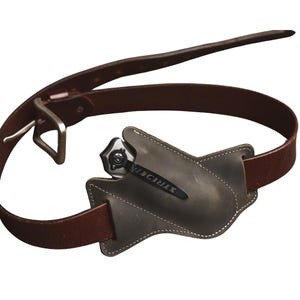 Peut inclure: Une ceinture en cuir marron avec une boucle argent&eacute;e et un &eacute;tui en cuir gris contenant un couteau pliant. Le couteau a un manche noir et le mot "STRIDER" est imprim&eacute; sur la lame.