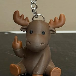 May include: A brown moose keychain with a silver chain. The moose is giving the middle finger. The moose has brown antlers, feet, and a middle finger. The keychain is a novelty item.
