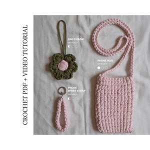 May include: A crochet PDF and video tutorial featuring three items: a dark olive green flower bag charm with a pink center, a light pink phone wrist strap with a metal ring, and a light pink crocheted phone bag with a long matching shoulder strap.