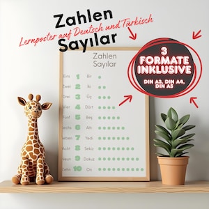 May include: A framed educational poster displaying numbers in German and Turkish, alongside a giraffe toy and a potted plant. The poster reads "Zahlen Sayılar" and "3 Formate Inklusive". The giraffe is brown and tan.