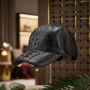 May include: A black baseball cap featuring a textured crocodile skin pattern across the crown and the curved brim. The cap is constructed with multiple panels of embossed leather, showcasing a detailed scale design and a structured silhouette.