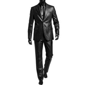 Può includere: Un completo nero con un motivo strutturato simile alla pelle di serpente. Il completo è composto da una giacca con revers a lancia e due tasche, e pantaloni abbinati. Il completo è esposto su un manichino.