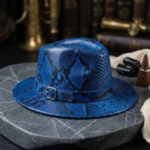 Sombrero fedora azul eléctrico con estampado de piel de serpiente: un accesorio llamativo con textura exótica.