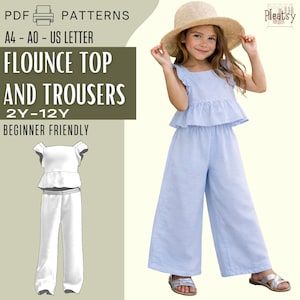 Może przedstawiać: Dziewczynka w jasnoniebieskim topie z falbanami i spodniach, w połączeniu ze słomkowym kapeluszem i sandałami. Obraz zawiera również wzór na top z falbanami i spodnie, z tekstem "FLOUNCE TOP AND TROUSERS 2Y-12Y BEGINNER FRIENDLY."