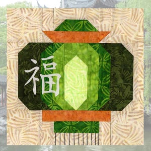 May include: A patchwork design featuring a stylized green lantern with the Chinese character "Fu" in white. The lantern is set against a beige background with a leaf pattern, with a blurred background of a traditional Asian building and water.