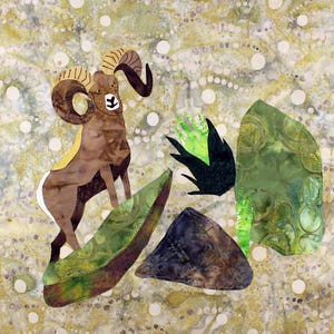 Op de afbeelding: Een textielkunstwerk met een ram met grote, gebogen hoorns, geplaatst in de buurt van groene en bruine rotsformaties en een donkergroene plant. De achtergrond heeft een gevlekt patroon van geel, wit en bruin.