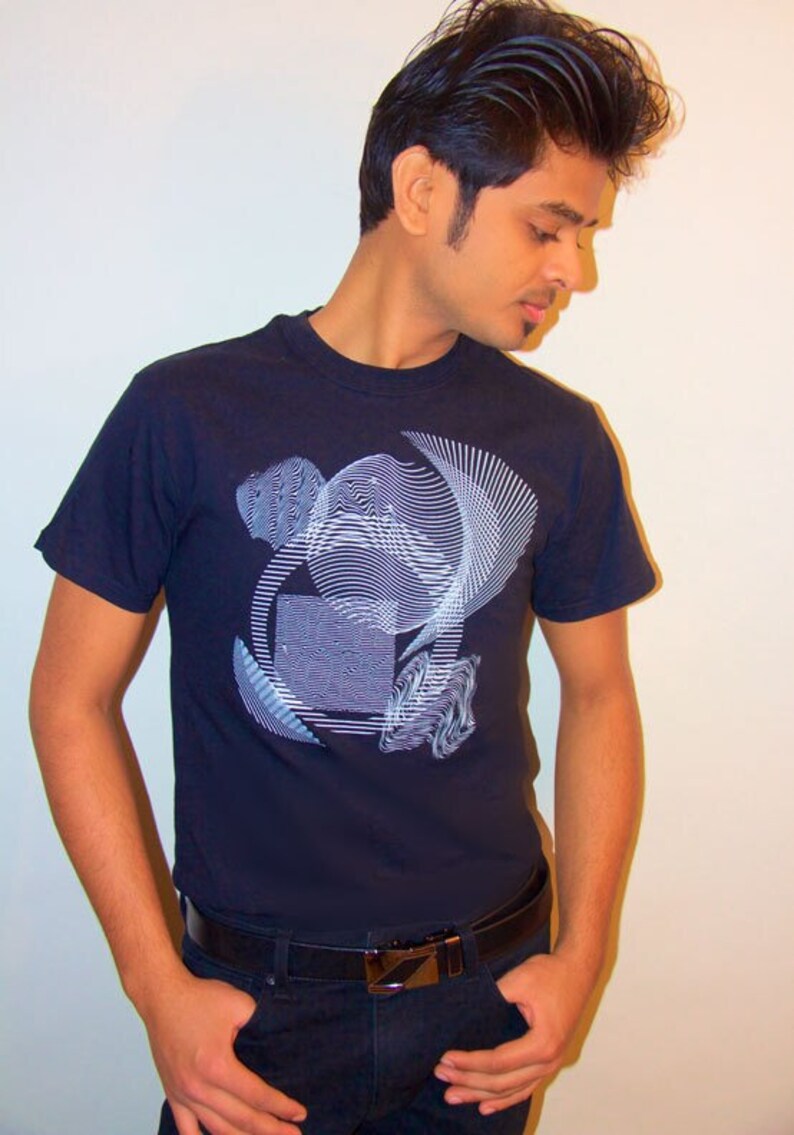 May include: A man wearing a dark blue t-shirt with a white geometric design. He is wearing a black belt and dark blue jeans.
