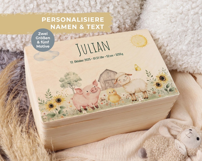 May include: A light-colored wooden box with a painted farm scene featuring a pig, sheep, and chick. The box has the name "JULIAN" in green, along with birth details. Text on the box reads "PERSONALISE NAMEN & TEXT" and "Zwei Gr&ouml;&szlig;en & f&uuml;nf Motive".
