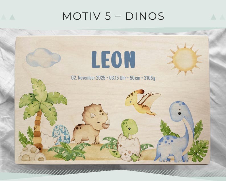 May include: Wooden plaque with a dinosaur theme. The plaque features the name "LEON" in blue, along with illustrations of dinosaurs, a sun, a cloud, and palm trees. The text "MOTIV 5 - DINOS" is at the top.