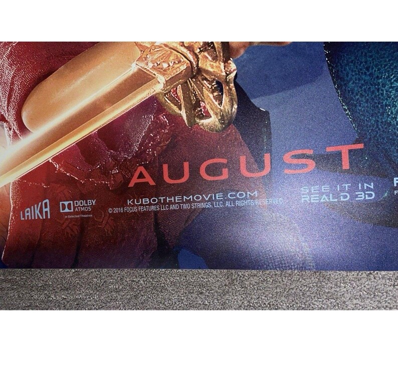 K&ouml;nnte beinhalten: Ein Filmplakat mit dem Wort "AUGUST" in Rot. Das Bild zeigt ein goldfarbenes Schwert und die Logos von LAIKA und Dolby Atmos. Der Text "SEE IT IN REALD 3D" ist ebenfalls auf dem Plakat zu sehen.