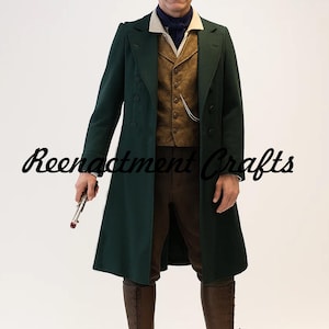 May include: A dark green overcoat with a double-breasted design, worn over a gold vest and brown trousers. The outfit includes a white collared shirt and a blue scarf. The text "Reenactment Crafts" is written in cursive on the coat.