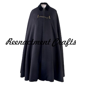 Op de afbeelding: Een zwarte cape met een fluwelen kraag en een sluiting met gesp. De cape is lang en vloeiend, met de tekst "Reenactment Crafts" in cursiefschrift onderaan. De cape wordt gepresenteerd op een witte achtergrond.