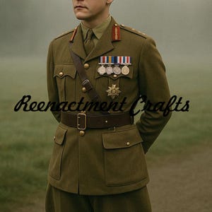 Può includere: Uniforme militare verde oliva con cintura e tracolla marrone. L'uniforme presenta più tasche, bottoni dorati e medaglie. Il testo "Reenactment Crafts" è visibile in basso a sinistra.