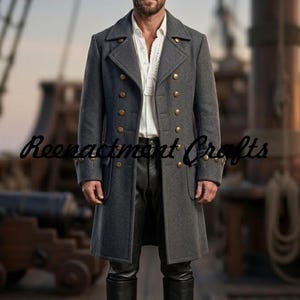 Puede incluir: Un abrigo de lana gris carbón de doble botonadura con dos filas de botones color latón, solapas anchas y mangas largas con puños abotonados. El abrigo se lleva sobre una camisa blanca y pantalones negros. El texto Reenactment Crafts es visible.
