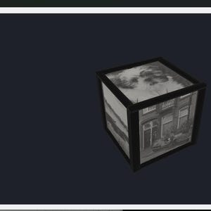 May include: A black and white cube with images of a building on its sides. The cube is set against a dark background. The images on the cube appear to be of a building with windows and a door. The top of the cube has a cloudy sky image.