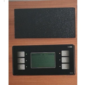 Puede incluir: Un panel de control negro con una pantalla digital que muestra números y símbolos. El panel tiene varios botones y un indicador de 12V. La marca "CBE" es visible. Un panel negro texturizado separado está encima.