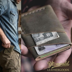 May include: A green leather wallet with a dollar bill and a card visible. The wallet is held open, showcasing its contents. The text "Ytcmould LEATHERGOODS HANDMADE" is visible.