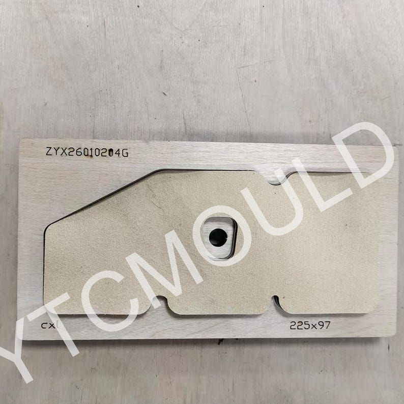 May include: A wooden die-cut mold with a unique shape, featuring a central circular opening and a rectangular form. The dimensions are 225x97. The text "ZYX26010204G" and "CX" are visible. The logo "YTCMOULD" is also visible.