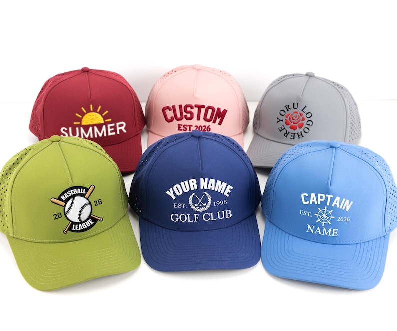 May include: Six baseball caps in various colors, including red, pink, and blue. Each cap features embroidered text and designs, such as "SUMMER," a baseball graphic, and "CAPTAIN." The caps have a mesh back for breathability.