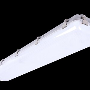 May include: A white, rectangular LED light fixture with a translucent cover and metal clips. The fixture is designed for overhead lighting and is suitable for commercial or industrial applications.