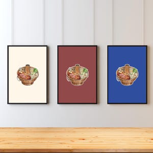 Könnte beinhalten: Drei gerahmte Drucke mit Illustrationen eines Hot-Pot-Gerichts. Jeder Druck hat eine andere Hintergrundfarbe: Creme, Burgunderrot und Blau. Der Hot Pot befindet sich in einem kupferfarbenen Topf mit Gemüse und Fleisch.