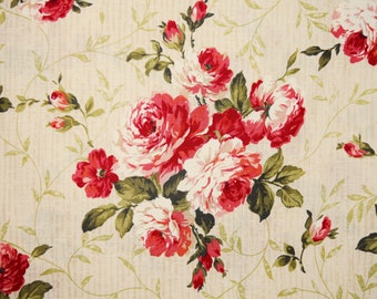 May include: Floral fabric featuring a repeating pattern of red and white roses with green leaves and stems on a cream-colored background. The roses are in full bloom, creating a classic, romantic design.