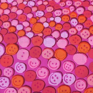 May include: A pink fabric with a repeating pattern of orange, pink, and white circles. The circles have a smiley face design.
