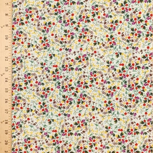 May include: White fabric with a repeating pattern of small red, yellow, purple, and green flowers. The fabric has a subtle texture.