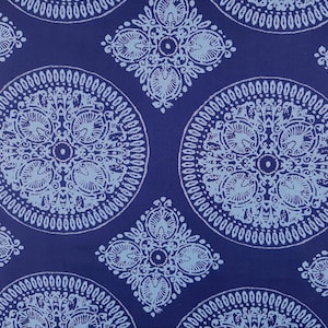 May include: Blue fabric with a white and light blue patterned design. The pattern features repeating circles and diamond shapes with intricate details.