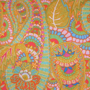 Op de afbeelding: Een levendig, kleurrijk textiel met een paisley- en bloemenpatroon. Het ontwerp bevat oranje, roze, blauwe, groene en gele tinten. De ingewikkelde details omvatten blad- en waaiervormen, waardoor een levendig en opvallend ontwerp ontstaat.