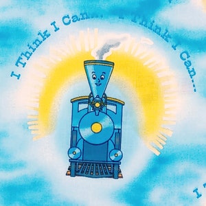 Könnte beinhalten: Eine blaue Lokomotive mit einem lächelnden Gesicht und einem gelben Sonnenstrahl dahinter. Der Text "I Think I Can... I Think I Can..." ist um den Sonnenstrahl herum geschrieben.