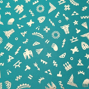 Puede incluir: Tela turquesa con un patrón blanco repetitivo de varias formas geométricas y símbolos. El patrón incluye flechas, estrellas, rayos y otros diseños abstractos.