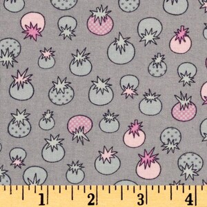 Op de afbeelding: Een grijze stof met een herhalend patroon van witte en roze gestileerde bloemen. De bloemen hebben een witte omtrek en een roze centrum met witte stippen. De stof wordt gemeten met een liniaal in inches.