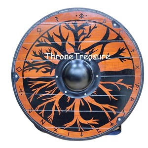 Könnte beinhalten: Ein runder Holzschild mit einem schwarzen und orangefarbenen Lebensbaum-Design. Der Schild hat einen zentralen Metallknauf und den Text "Throne Treasure". Der Schild hat einen Durchmesser von etwa 76 cm.