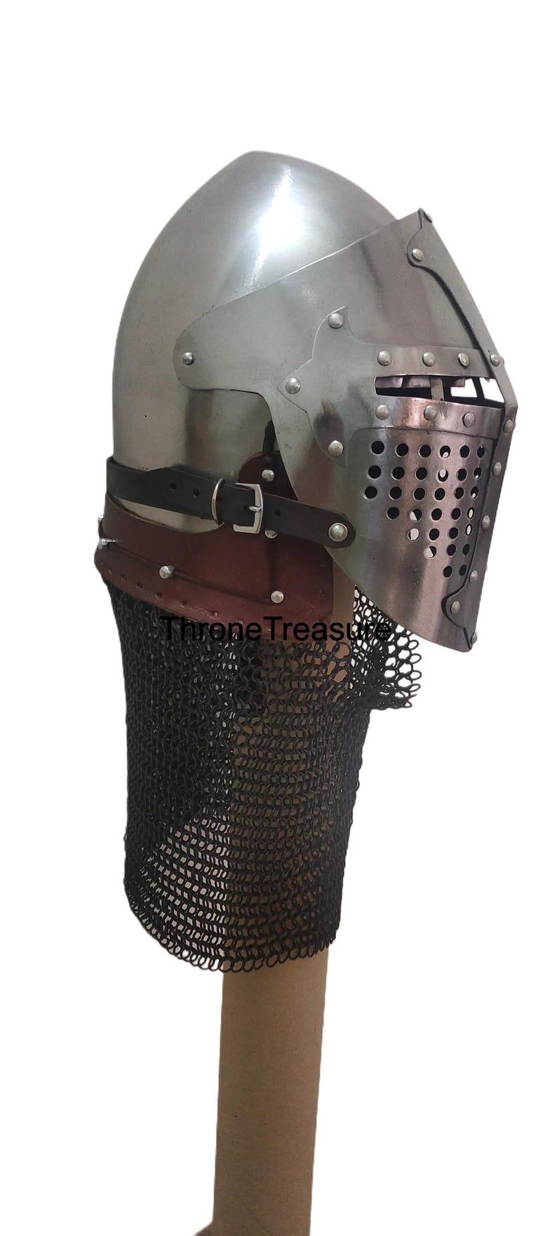 Pu&ograve; includere: Un elmo a bacinetto in acciaio lucido con visiera incernierata e piastra frontale perforata, cinturino in pelle marrone con fibbia in metallo e una ventaglia di maglia metallica scura fissata alla base. Il testo ThroneTreasure &egrave; visibile.