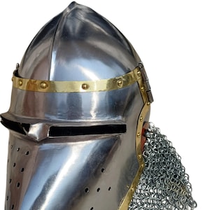 May include: A polished steel medieval helmet with a pointed top, brass trim, and a visor with a narrow eye slit. The helmet features a chainmail aventail and is designed for protection.