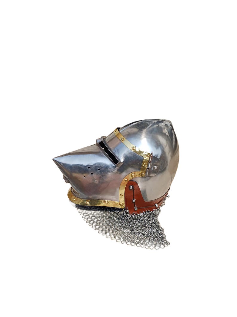 May include: A polished metal helmet with a pointed visor, brass detailing, and a leather and chainmail neck guard. The helmet is designed for protection and historical reenactment.