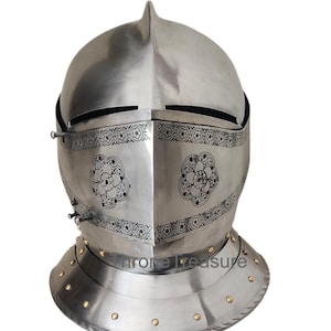 Könnte beinhalten: Ein polierter silberner Ritterhelm mit spitzer Spitze und klappbarem Visier. Das Visier weist dekorative Blumenmuster auf und ist am Helm vernietet. Der Nackenschutz hat eine Reihe von Nieten am unteren Rand. Der Text "Throne Treasure" ist sichtbar.