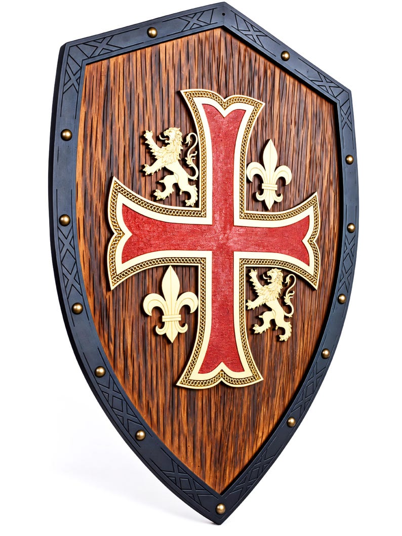 May include: A wooden shield featuring a dark brown textured surface with a black border accented by metal studs. A large red cross with gold trim is centered, flanked by two gold lion figures and two gold fleur-de-lis symbols on the wood panel.