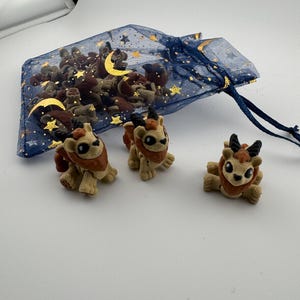 May include: A white ceramic mug with a black handle and the text "But First, Coffee" in a black, handwritten-style font. The mug is on a white surface.