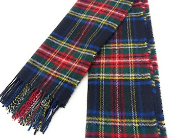May include: A navy blue plaid scarf with a fringed edge. The scarf features a classic tartan pattern in red, green, yellow, and white. The scarf is made of a soft, woven material.