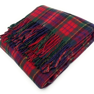May include: Folded red, green, and blue tartan blanket with fringed edges. The blanket displays a traditional plaid pattern, with a mix of red, green, and blue colours. The fringed edges add a decorative touch to the cosy blanket.