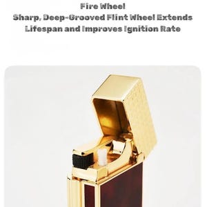 May include: A gold-colored lighter with a rectangular body and a flip-top lid. The lighter has a dark red and gold patterned design on the body. The text "Fire Wheel" and other text is visible on the image.