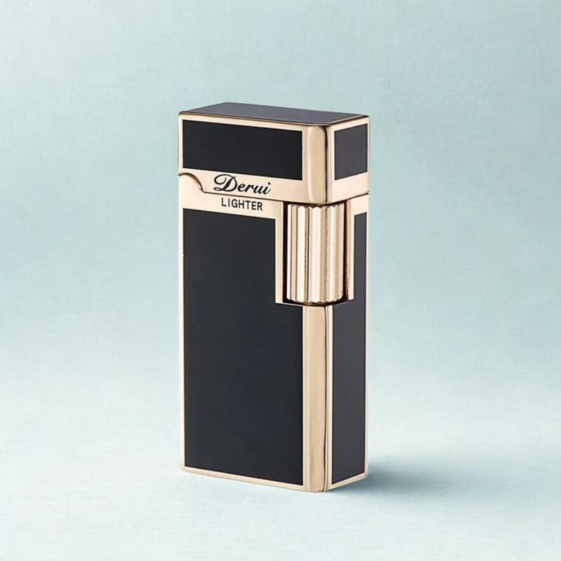 May include: A black and gold lighter with the text "Derui Lighter". The lighter has a rectangular shape with gold accents and a ribbed wheel. The lighter is a sleek and stylish accessory.