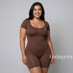 Puede incluir: Un body marrón con cuello cuadrado y mangas cortas. La prenda de una pieza tiene un diseño ajustado y pantalones cortos. El nombre de la marca "Gainyera" está impreso en blanco en la parte inferior derecha de la imagen.