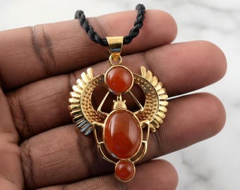 Gouden gevleugelde scarabee met carneool edelsteen | Egyptische Revival Amuletketting | Statement sieraden van messing