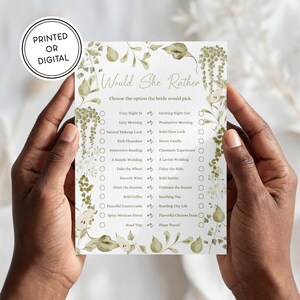 May include: A rectangular game card titled Would She Rather with a botanical border of green leaves and pears. The text reads Choose the option the bride would pick followed by a list of choices with checkboxes. A circular badge says PRINTED OR DIGITAL.