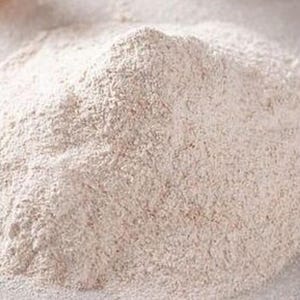 May include: A close-up shot of a pile of light brown flour. The flour has a fine, powdery texture and appears to be freshly milled. The image is well-lit, highlighting the texture and color of the flour.